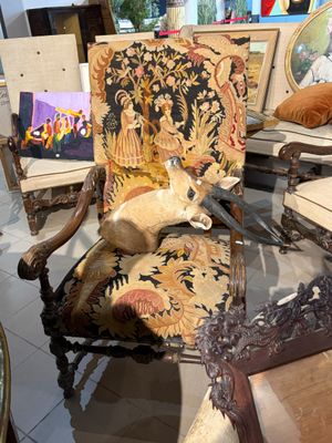 un chat assis sur une chaise au milieu d'une pièce