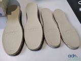three pairs of white shoes are lined up on a table