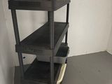 a black shelf that is in the corner of a room