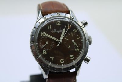 a close up of a watch with a brown leather strap