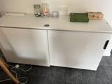 a white cabinet that has a green box on top of it