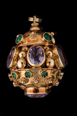 une image représentant une broche en or et en améthyste, ornée de pierres vertes et violettes