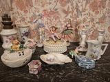 many different types of porcelain figurines displayed on a table