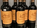 Six bouteilles de Château Fonnéaux sont alignées sur une table en verre.