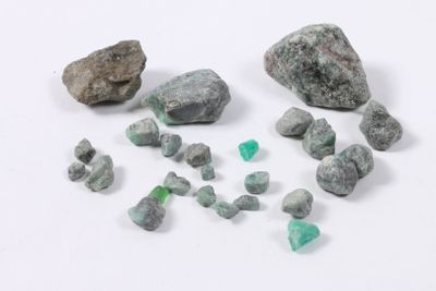 plusieurs morceaux de roches et de pierres vertes et blanches posés sur une surface blanche