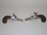 pair of antique silver plated pistols on clear acrylic bases