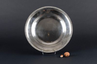 an antique silver plate with beaded edge and a small nut