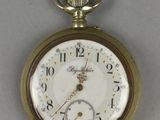 a gold pocket watch with roman numerals on the face