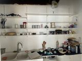 une cuisine équipée d'un évier, d'une cuisinière et d'étagères