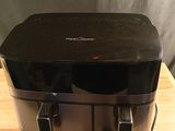 an image of a black toaster sitting on top of a wooden cutting board
