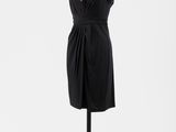 une robe noire posée sur un mannequin, sur fond blanc