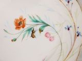 a plate with a flower and a bee painted on it