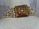 gold and red beaded belt with a square buckle