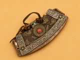 une vieille broche argentée et rouge sur fond marron