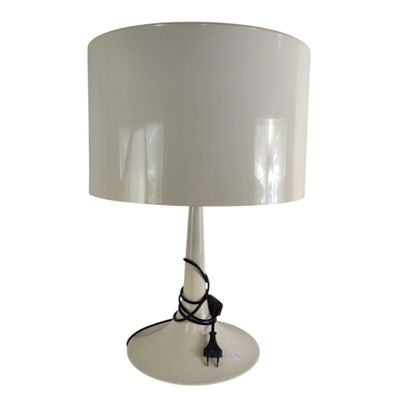un gros plan d'une lampe posée sur une table, avec un abat-jour blanc
