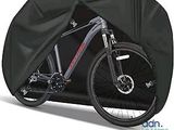 Le vélo est recouvert d'une housse noire pour le protéger du soleil.