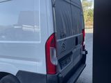 the back end of a white van parked in a parking lot