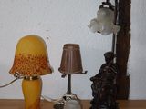 a table with a lamp, a lamp shade, and other items on it