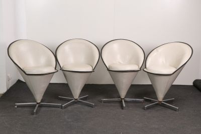 three white chairs with black trims sit in front of a white wall