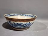 an old blue and white bowl sitting on top of a table