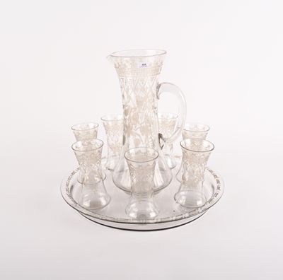 un plateau en argent sur lequel sont posés un pichet en verre et des tasses