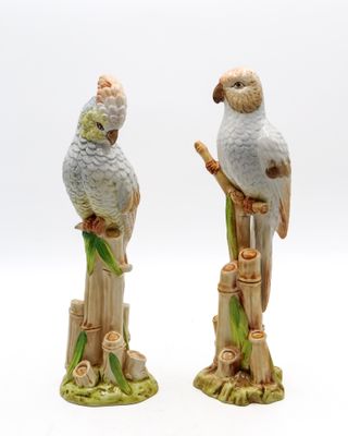 deux figurines d'oiseaux perchées sur une souche d'arbre