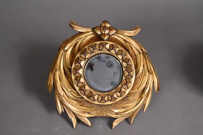 a gold clock with a mirror in the middle of it
