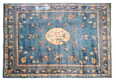un vieux tapis bleu orné d'un motif floral