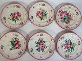 six assiettes ornées de fleurs roses et de feuilles vertes
