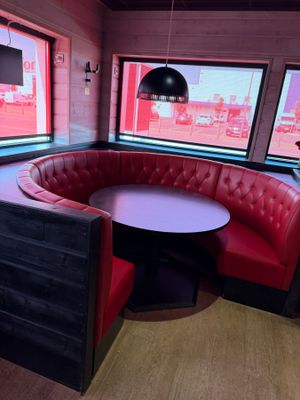 une cabine rouge avec une table ronde et des chaises rouges