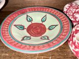 une assiette ornée d'une rose, posée sur une table
