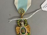 une image représentant une médaille entourée d'un ruban et à laquelle est attachée une étiquette