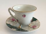 a cup and saucer on a saucer on a white table
