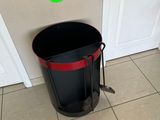 a black trash can sitting on the floor next to a white door