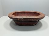an old wooden bowl sitting on top of a white table