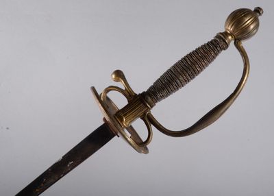 un gros plan d'une épée avec une poignée en métal sur fond blanc