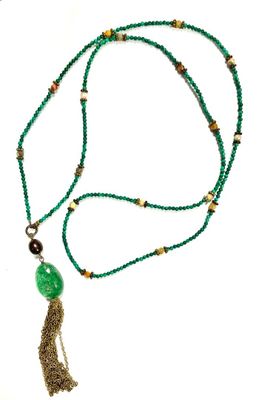 beaded necklace with a green pendant and a tassel on a white background
