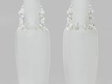 une paire de vases blancs, chacun muni d'une anse perlée