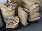 a pile of bags sitting on a pallet next to a refrigerator
