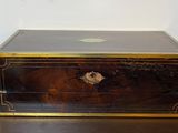 une boîte noire et dorée posée sur une table en bois