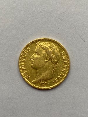 gros plan d'une pièce d'or sur une surface blanche