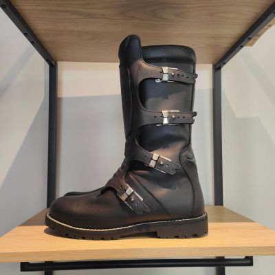 une paire de bottes noires posée sur une étagère en bois dans une pièce
