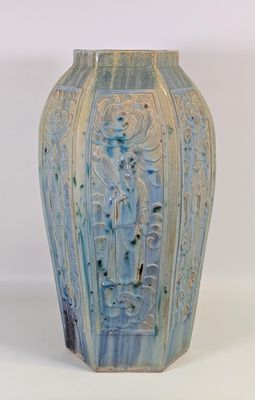 un vase bleu sur lequel est représentée une femme