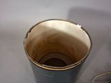 a black bucket with a brown lid sitting on a table