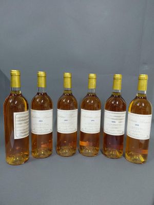 six bouteilles de vin sont alignées sur une table