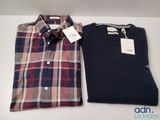 two men ' s shirts are sitting on a table with tags on them