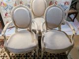three white chairs sitting on top of a rug in a room