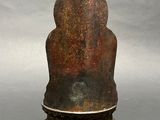 a small statue of a person sitting on a pedestal