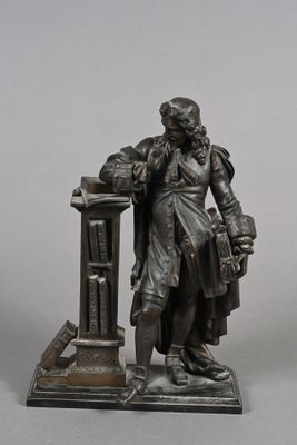 a statue of a man standing next to a book shelf
