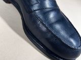 a close up of a pair of blue loafers on a white surface